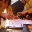 Industrial workers reviewing job hazard analysis and permit documentation as part of contractor safety oversight.